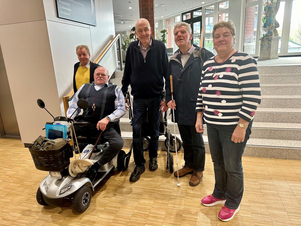 Workshop des Behindertenbeirates im Kreishaus Eine Personengruppe steht vor einer Treppe im Foyer eines Gebäudes.